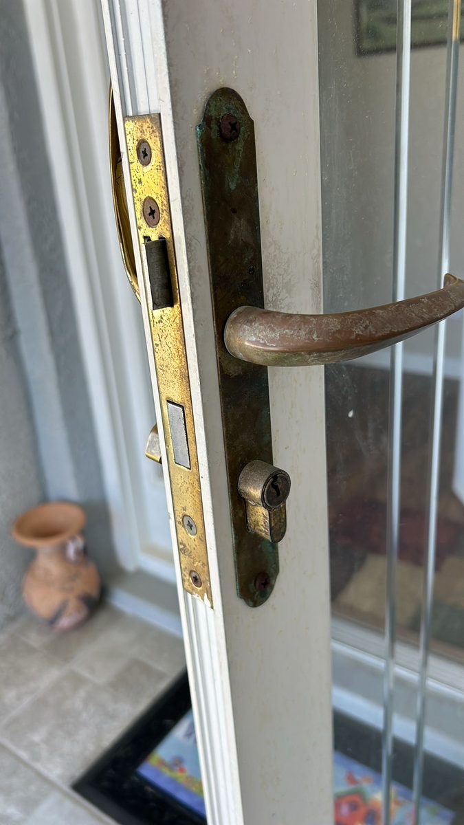 Locksmith swapping out storm door locks for a homeowner